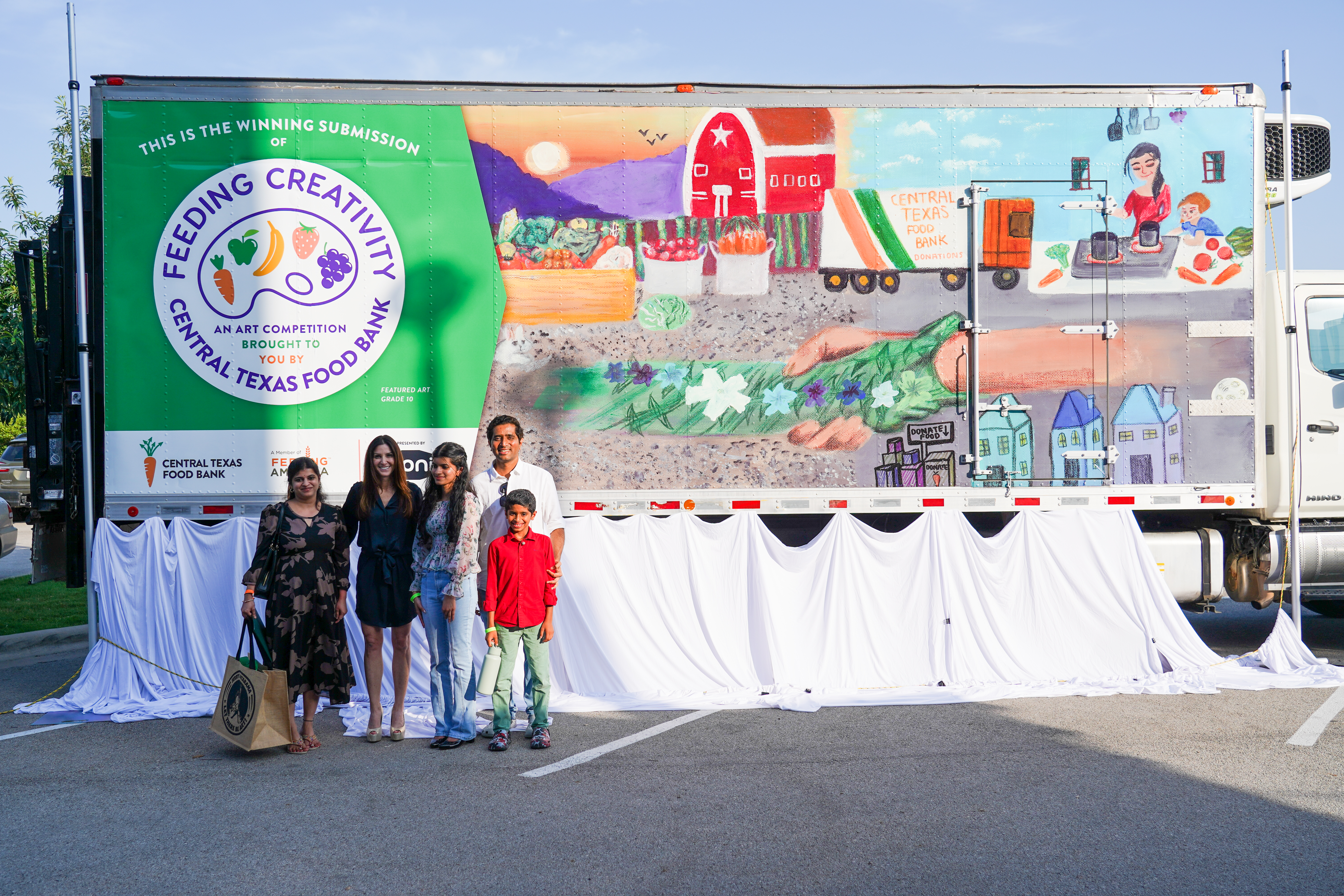 Feeding Creativity 2024 winner with family and CTFB CEO in front of food bank truck