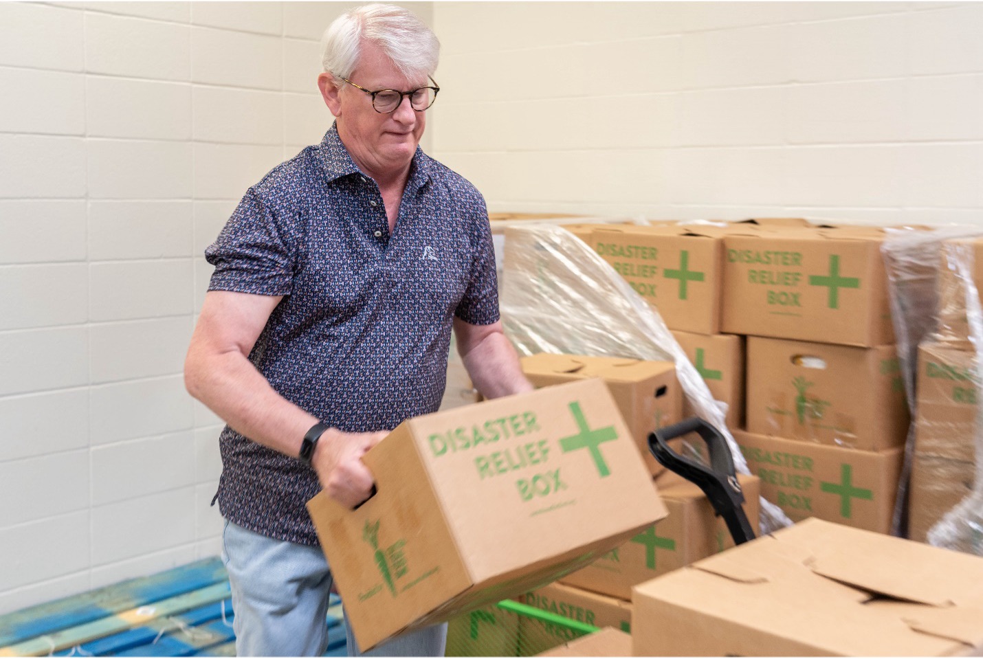 Food Bank volunteer Trey holds disaster relief box of food